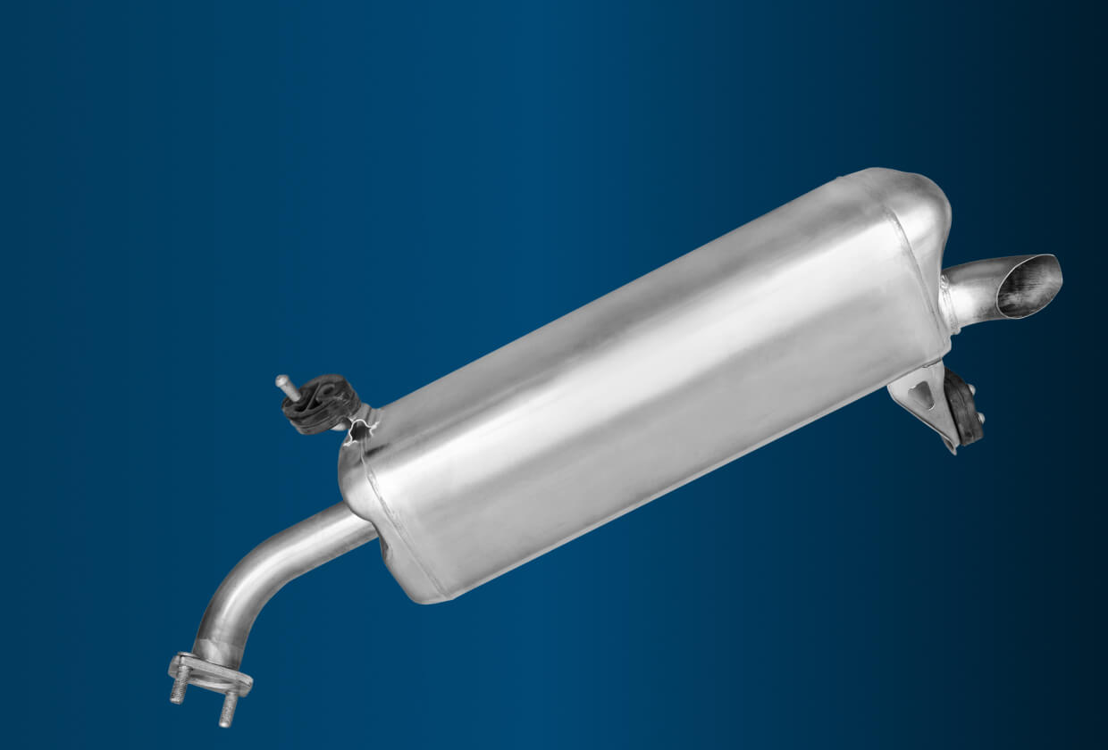 Exhaust system repair in Madison, WI at Torque Automotive. A metallic car muffler with curved pipes and mounting brackets, displayed on a gradient blue background.